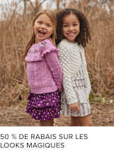 Deux jeunes filles, l'une aux longs cheveux blonds et l'autre aux cheveux noirs bouclés, s'embrassent et sourient joyeusement dans un champ d'herbes hautes.