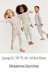 Trois jeunes enfants, deux filles et un garçon, vêtus de pyjamas à motifs colorés, se tiennent ensemble et sourient sur un fond blanc lumineux.
