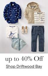 Una colección de prendas de vestir infantiles, que incluye una chaqueta azul marino estampada, un suéter beige con capucha, una camisa a rayas y un par de pantalones de color claro, todo ello expuesto sobre un fondo blanco liso con el texto "hasta un 40 % de descuento en Driftwood Bay" superpuesto.
