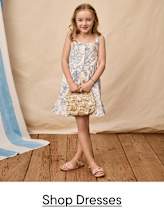 A collection of various children's swimwear and accessories, including a white blouse, a striped swimsuit, a blue and white long-sleeved top, and a pair of brown sandals, all arranged on a plain background with a "up to 40% Off" text overlay.
