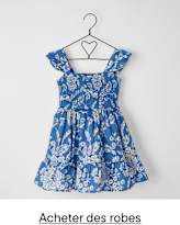 Une robe à motifs floraux bleus et blancs est suspendue à un cintre en métal noir sur un fond blanc uni.