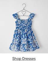 A blue and white floral patterned dress hangs on a black metal hanger against a plain white background.