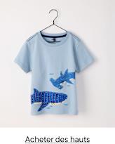 Un t-shirt bleu clair orné d'un motif graphique représentant deux requins bleus sur fond blanc, suspendu à un cintre noir.