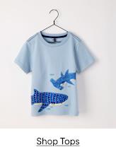 A light blue t-shirt with a graphic design featuring two blue sharks against a white background, hanging on a black clothing hanger.