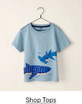 A light blue t-shirt with a graphic of two blue sharks and small fish is displayed on a hanger against a plain white background.