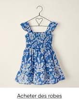 Une robe à motifs floraux bleus et blancs est suspendue à un cintre en métal noir sur un fond blanc uni.