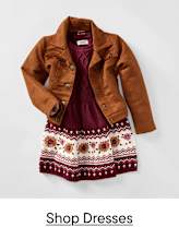 A brown fringed jacket is layered over a burgundy cable-knit dress with a patterned hem, all set against a plain white background.