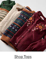 Four cozy sweaters, one with embroidered flowers in the foreground, are neatly arranged against a plain background.