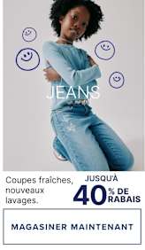 L'image montre un jeune homme aux cheveux noirs bouclés, vêtu d'une tenue en jean bleu clair, debout sur un fond blanc uni entouré de smileys bleus. Le texte en bas de l'image annonce « Nouvelles coupes, nouveaux délavages » et des réductions allant jusqu'à 50 %.