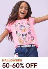 A young girl with long, curly hair is smiling and wearing a pink t-shirt with colorful cartoon characters printed on it, standing against a plain background.