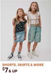 Two young girls wearing casual summer outfits, including denim shorts and skirts, posing against a plain white background with a text overlay promoting shorts, skirts, and more for $12 and up.