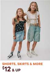 Two young girls wearing casual summer outfits, including denim shorts and skirts, posing against a plain white background with a text overlay promoting shorts, skirts, and more for $12 and up.