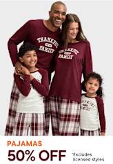 A happy family of four wearing matching burgundy and plaid pajamas, posing together in front of a plain background with a 50% off pajamas sale advertisement.