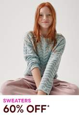 A young woman with vibrant red hair sits cross-legged, wearing a light blue patterned sweater and a pink skirt, against a plain white background. The image appears to be an advertisement for a sweater sale, with the text "SWEATERS 60% OFF*" displayed prominently.