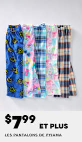 Une collection de pantalons de pyjama colorés et à motifs, comprenant des modèles avec des visages souriants, des imprimés floraux et des carreaux, disposés sur un fond uni avec un panneau de solde « 60 % de réduction ».