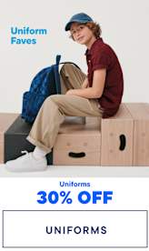 The image shows a smiling young woman wearing glasses, a navy blue sweater, and khaki pants, sitting on a stool and holding a pair of black shoes. The background is a plain white surface with the text "Uniform Faves" and "Uniforms 30% OFF" prominently displayed.