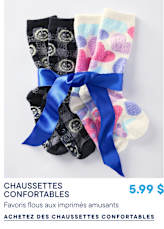 Deux paires de chaussettes duveteuses, l'une noire à motifs gris et l'autre blanche à cœurs colorés, sont attachées ensemble par un ruban bleu sur un fond blanc uni.
