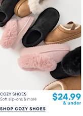 Various cozy slip-on shoes in black, pink, and brown are scattered across a plain white background.