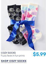 Two pairs of fuzzy socks, one black with grey patterns and one white with colorful hearts, are tied together with a blue ribbon against a plain white background.