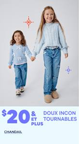 Deux jeunes filles en tenues en jean se tiennent la main et sourient, avec une publicité « Soft Must Haves » en arrière-plan.