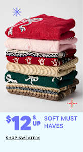 Two young girls wearing denim jeans and light blue sweaters are standing together and smiling, with a text overlay advertising sweaters for $14 and up.