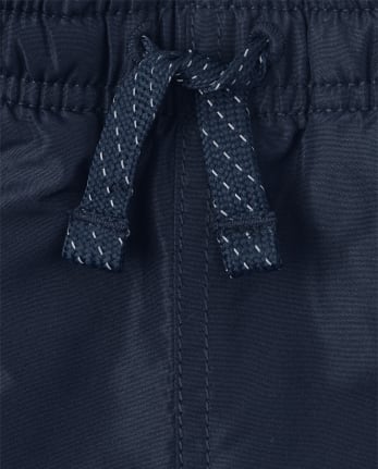 Pantalon coupe-vent à rayures latérales pour garçon
