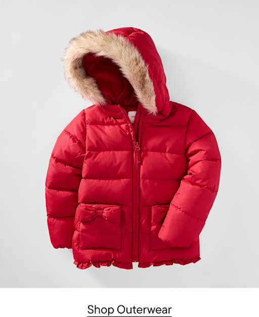 A red puffer jacket with a faux-fur trimmed hood sits against a plain light gray background.