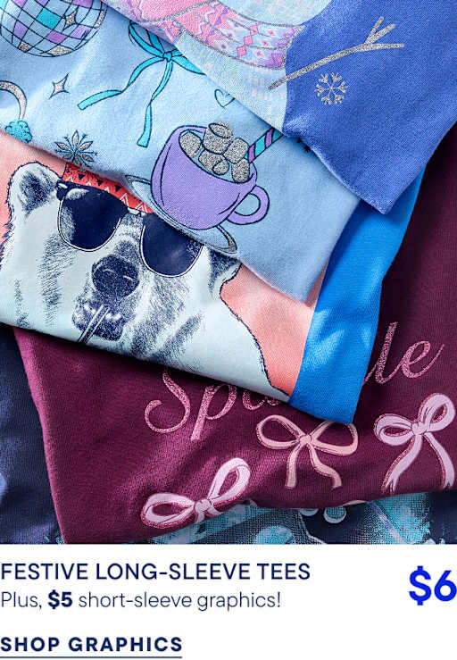 A stack of colorful graphic tees featuring a dog in sunglasses and a mug of cocoa sits atop a maroon shirt with pink bows.