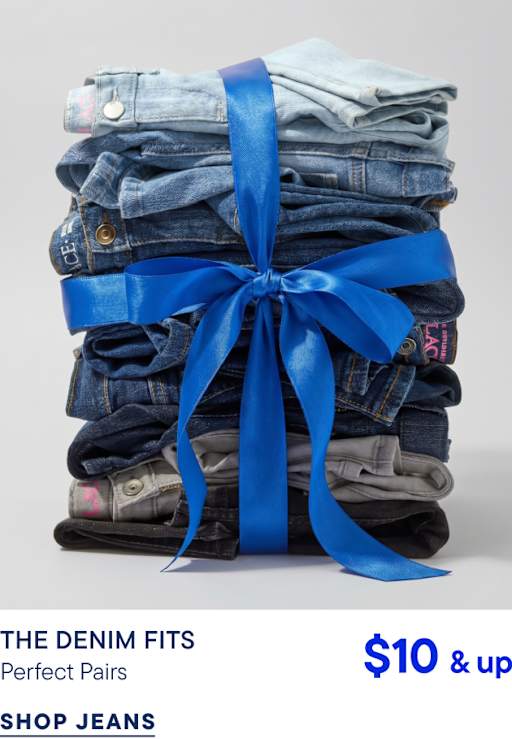 A stack of folded denim jeans tied with a bright blue ribbon sits against a plain light gray background.