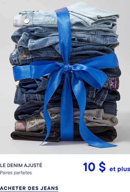 Une pile de jeans en denim pliés, noués par un ruban bleu vif, se détache sur un fond gris clair uni.