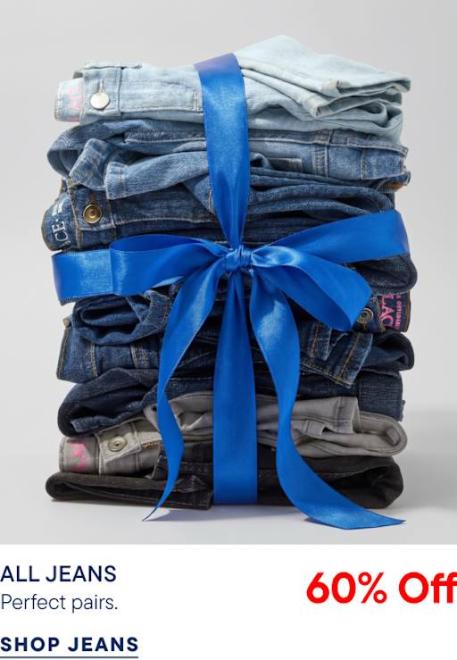A stack of folded denim jeans tied with a large blue ribbon sits against a plain light gray background.