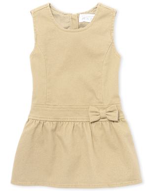 Un vestido beige sin mangas con un detalle de lazo en la cintura se exhibe sobre un fondo blanco liso.
