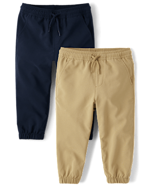 Se muestran dos pares de pantalones de niño en colores azul marino y beige sobre un fondo blanco liso.