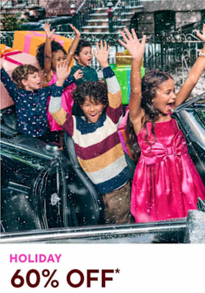 A group of excited children riding on a carnival ride, with their arms raised in the air, surrounded by a festive holiday atmosphere.