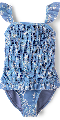 Un traje de baño con estampado floral azul y blanco, con corpiño fruncido y tirantes con volantes, sobre un fondo blanco liso.