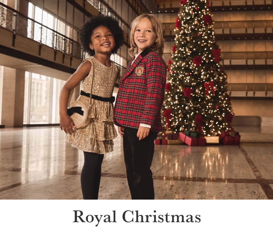 The image shows a red and black plaid jacket hanging on a wooden rack, with two women standing in the background in a festive setting with Christmas decorations.
