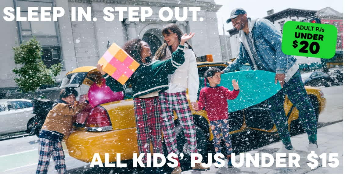 A group of people in colorful, patterned clothing stand in the snow, holding various objects and appearing to be engaged in some kind of festive or celebratory activity.