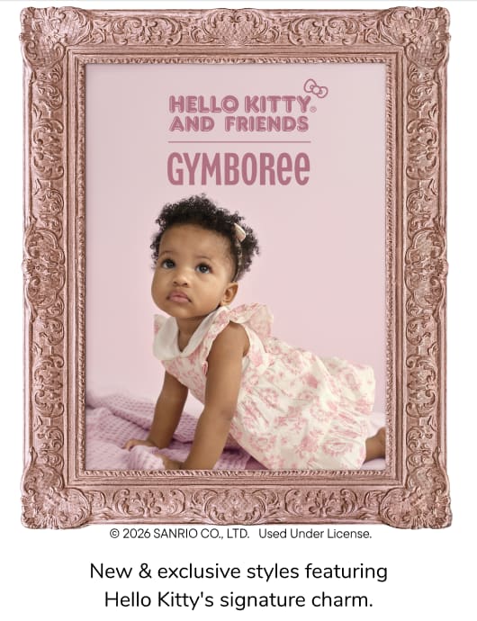 La imagen muestra a dos niños pequeños, un niño y una niña, sentados sobre una superficie suave y de color claro, con un fondo liso detrás de ellos.