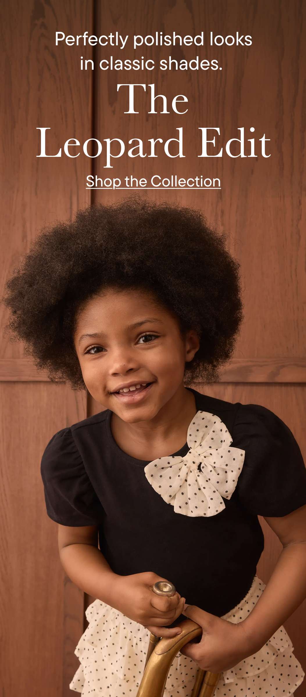 En primer plano aparece una niña sonriente con un peinado afro y un lazo de lunares en la camisa, con un fondo de madera y texto superpuesto en la parte superior de la imagen.