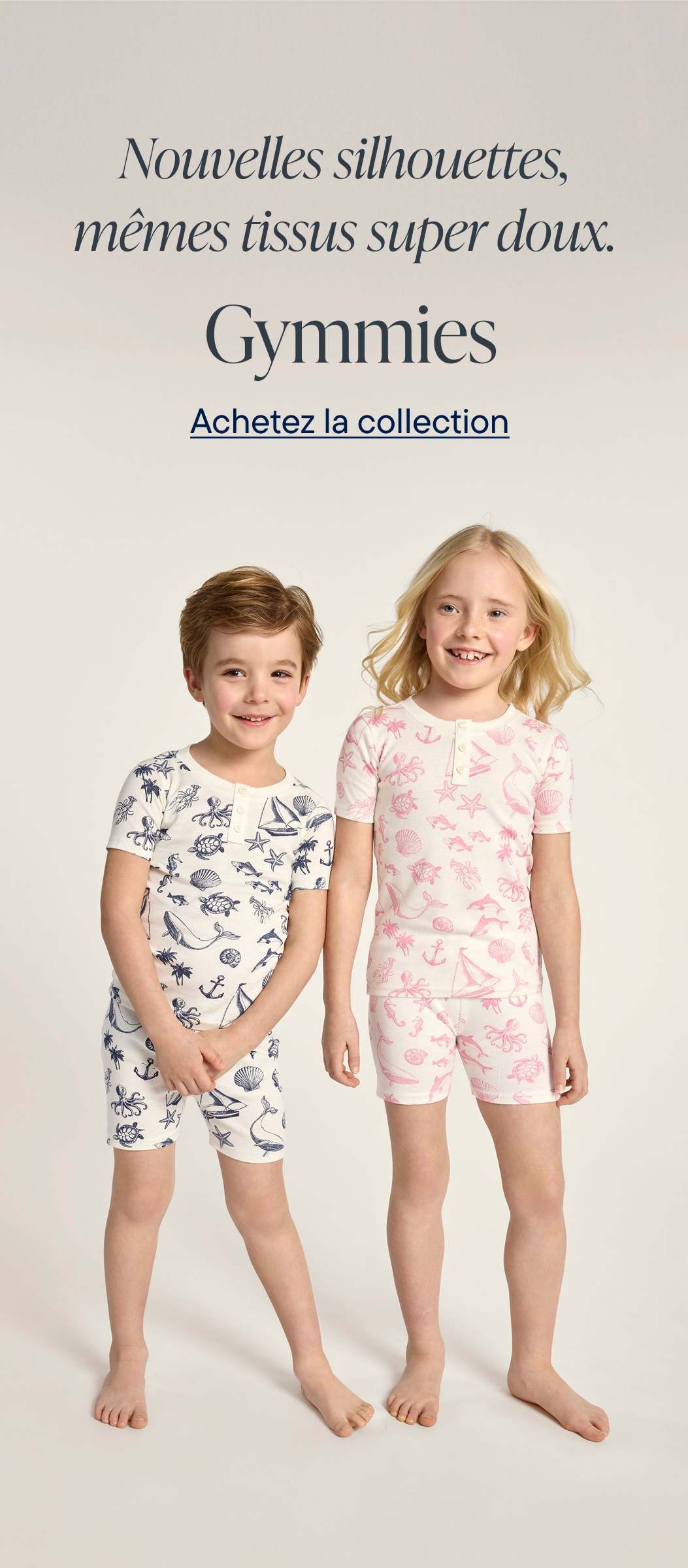 L'image présente deux jeunes enfants, un garçon et une fille, portant des ensembles de pyjamas assortis de la marque Gymnics sur un fond uni, mettant en valeur les nouvelles silhouettes et les tissus doux de la marque.