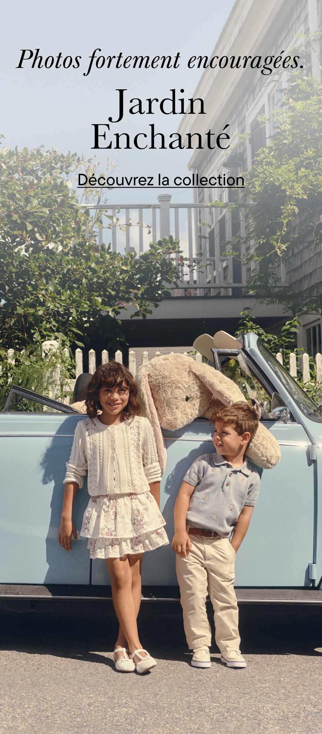 L'image montre deux jeunes enfants, une fille et un garçon, debout devant une camionnette de style vintage avec l'inscription « Jardin enchanté » affichée en évidence en arrière-plan.