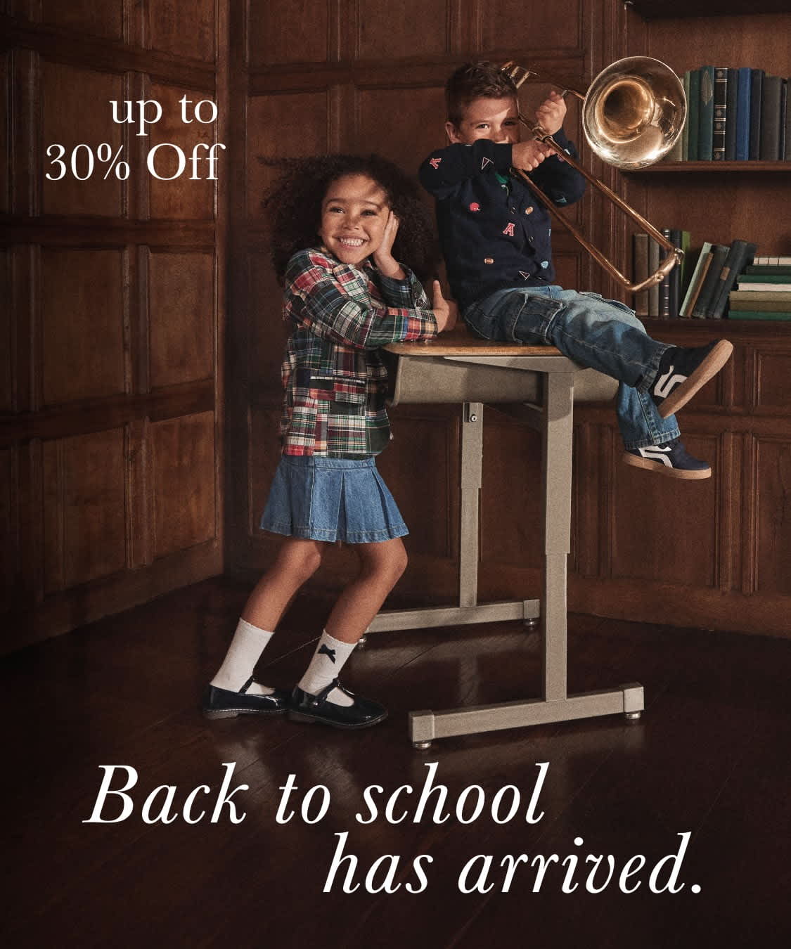 The image depicts a young girl standing on a stool in a rustic wooden room, with a boy sitting on a desk behind her. The text "Back to school has arrived" is displayed prominently, along with a discount offer of "XX% Off".