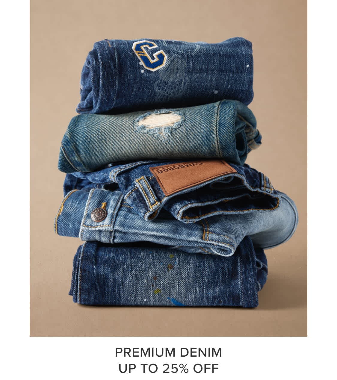 A stack of various denim clothing items, including jeans, jackets, and shirts, against a beige background.
