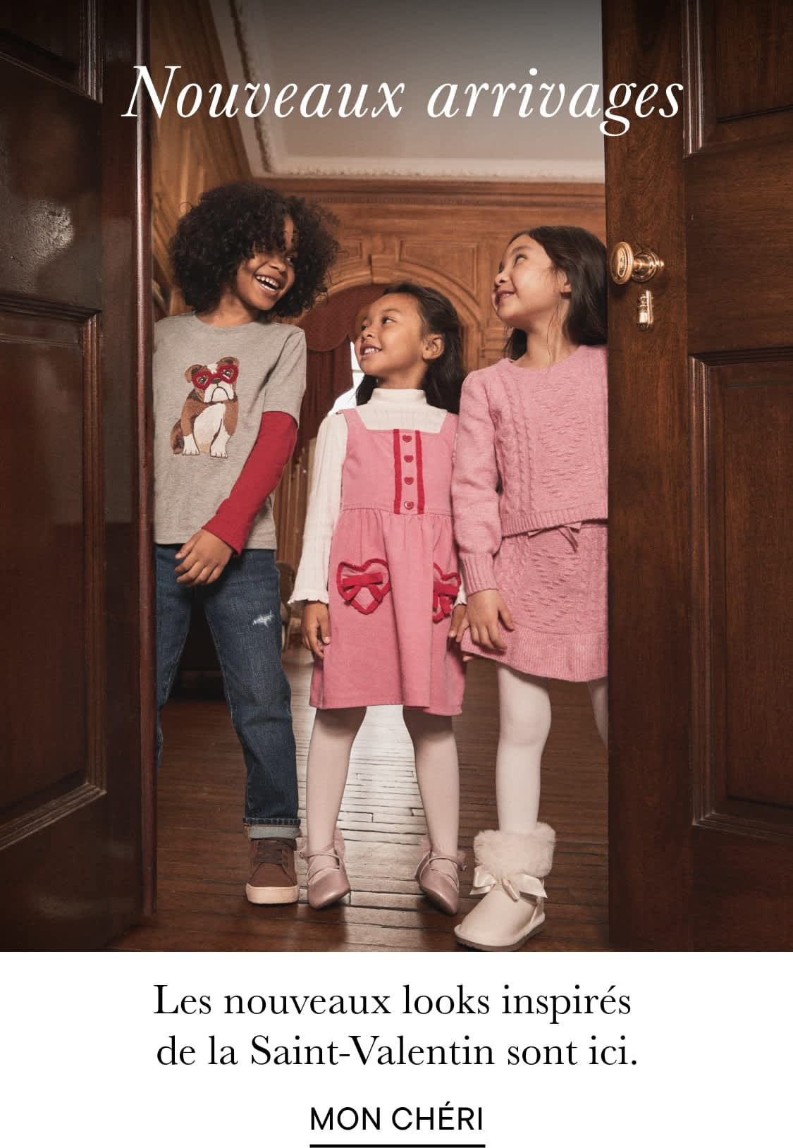 L'image montre un groupe de personnes, probablement une famille, debout ensemble dans ce qui semble être un intérieur domestique, avec en arrière-plan un étalage de vêtements et d'accessoires sur le thème de la Saint-Valentin.