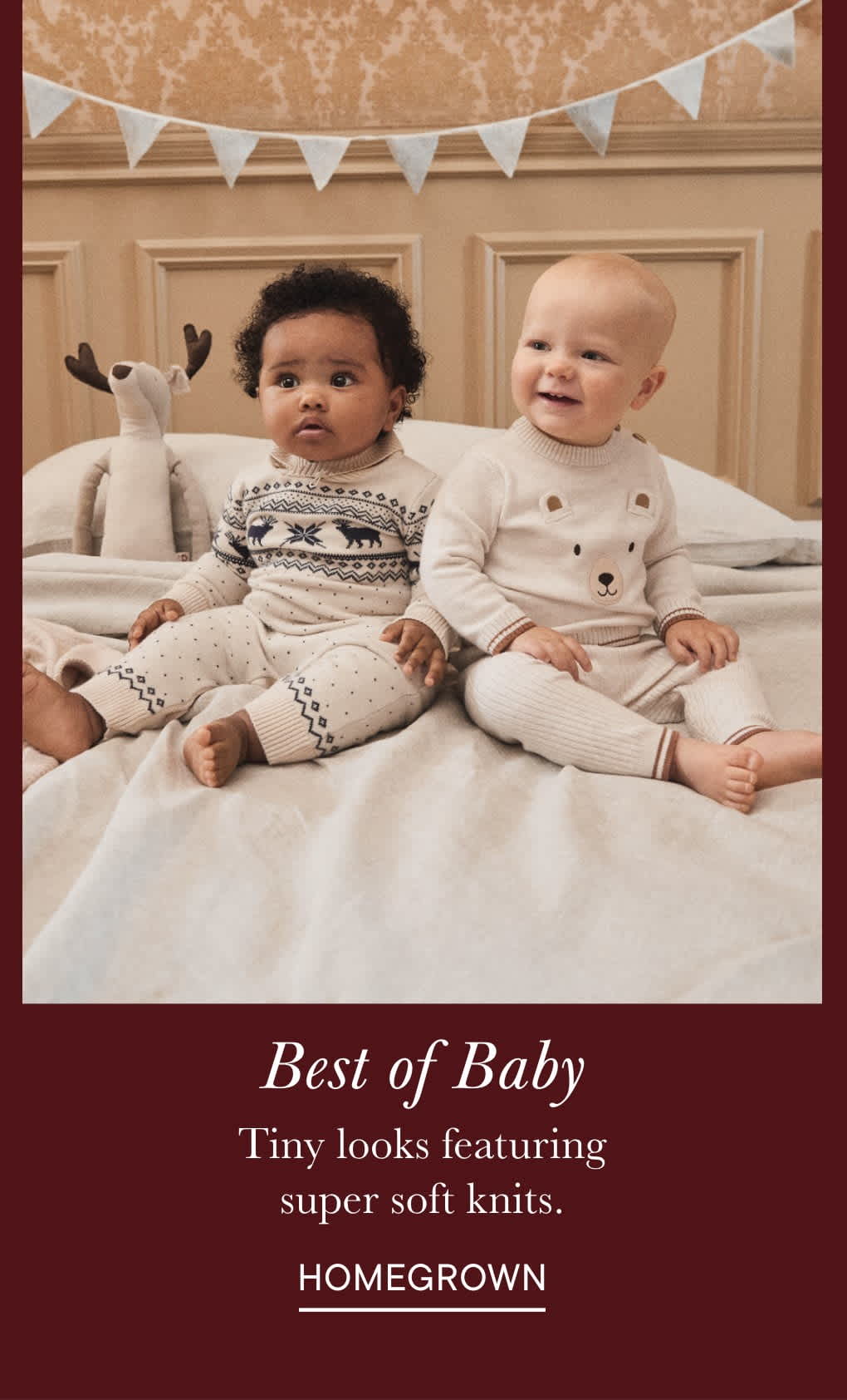 Two young children, a boy and a girl, sitting on a bed surrounded by festive decorations and a cozy, homey atmosphere.