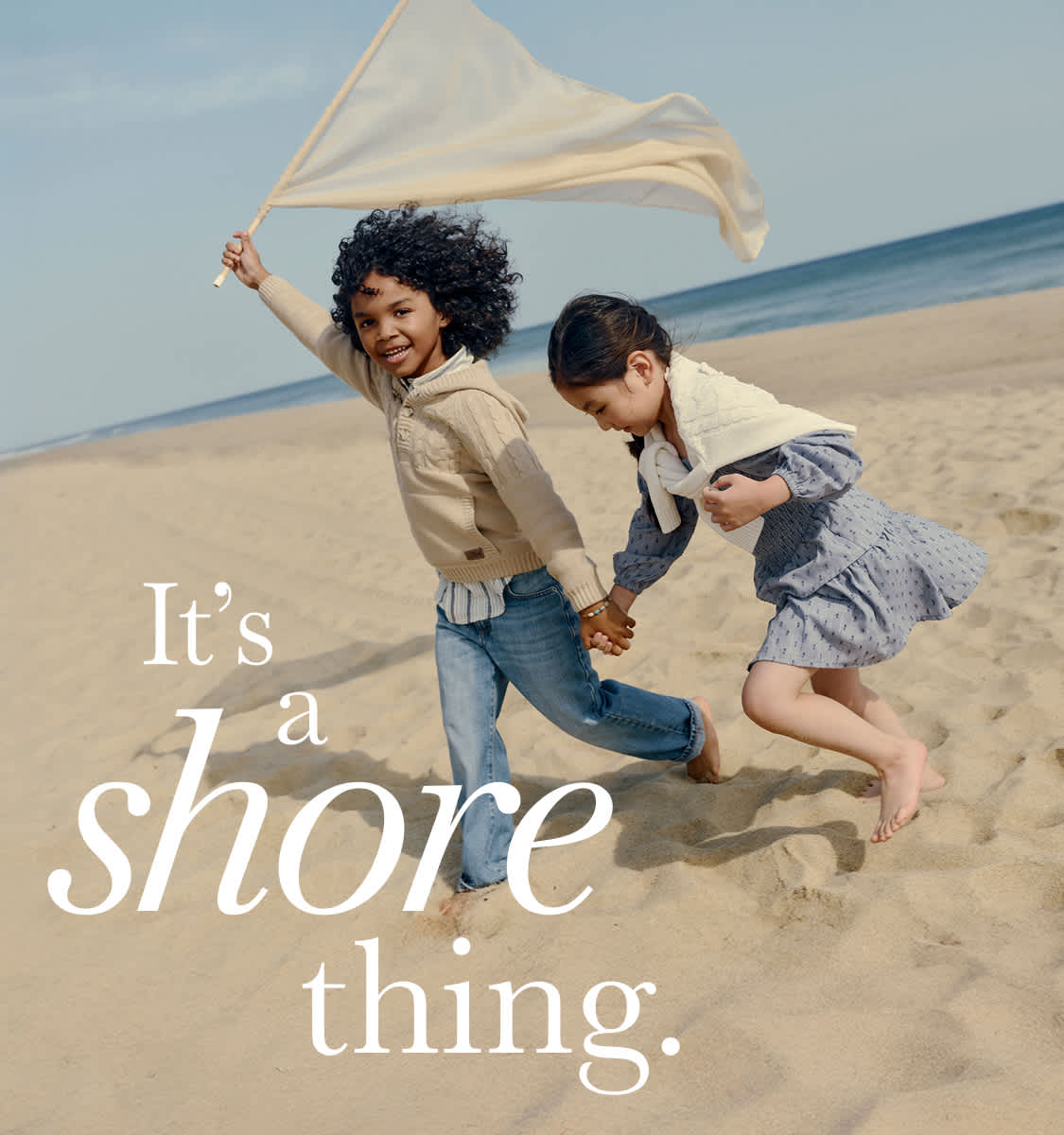 The image depicts a couple walking on a beach, with the text "It's a shore thing" overlaying the scene.