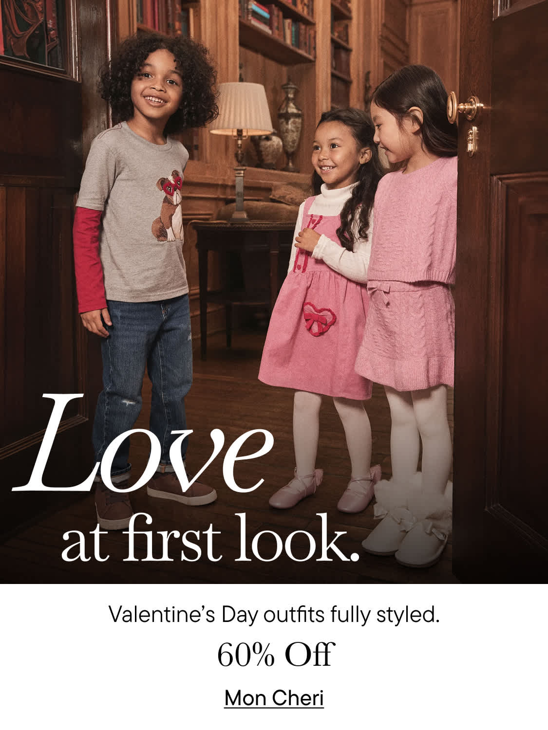 The image shows a group of young girls wearing matching pink outfits, standing in a cozy indoor setting with wooden shelves and decor in the background. Additionally, the image includes a display of Valentine's Day-themed clothing and accessories.