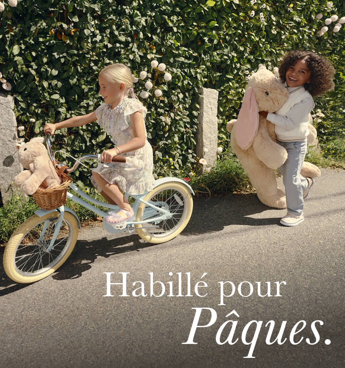 L'image montre deux personnes, une femme et un homme, vêtus de façon décontractée, debout à côté d'un vélo dans un cadre extérieur luxuriant et verdoyant.