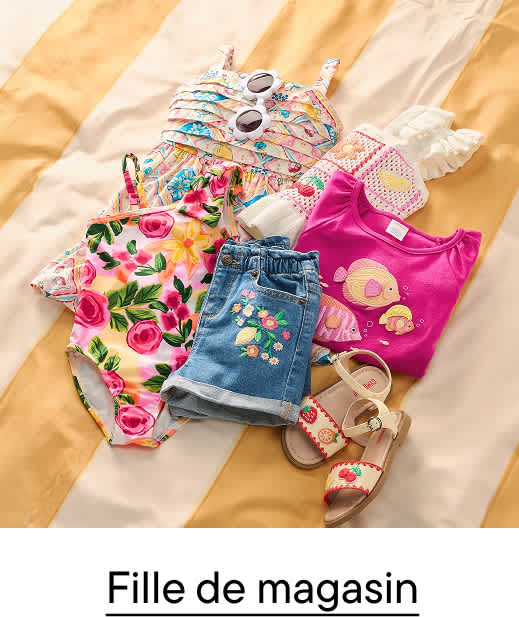 Une collection de vêtements d'été colorés pour enfants, comprenant un maillot de bain, un short et un t-shirt, est disposée sur une couverture à rayures jaunes et blanches.