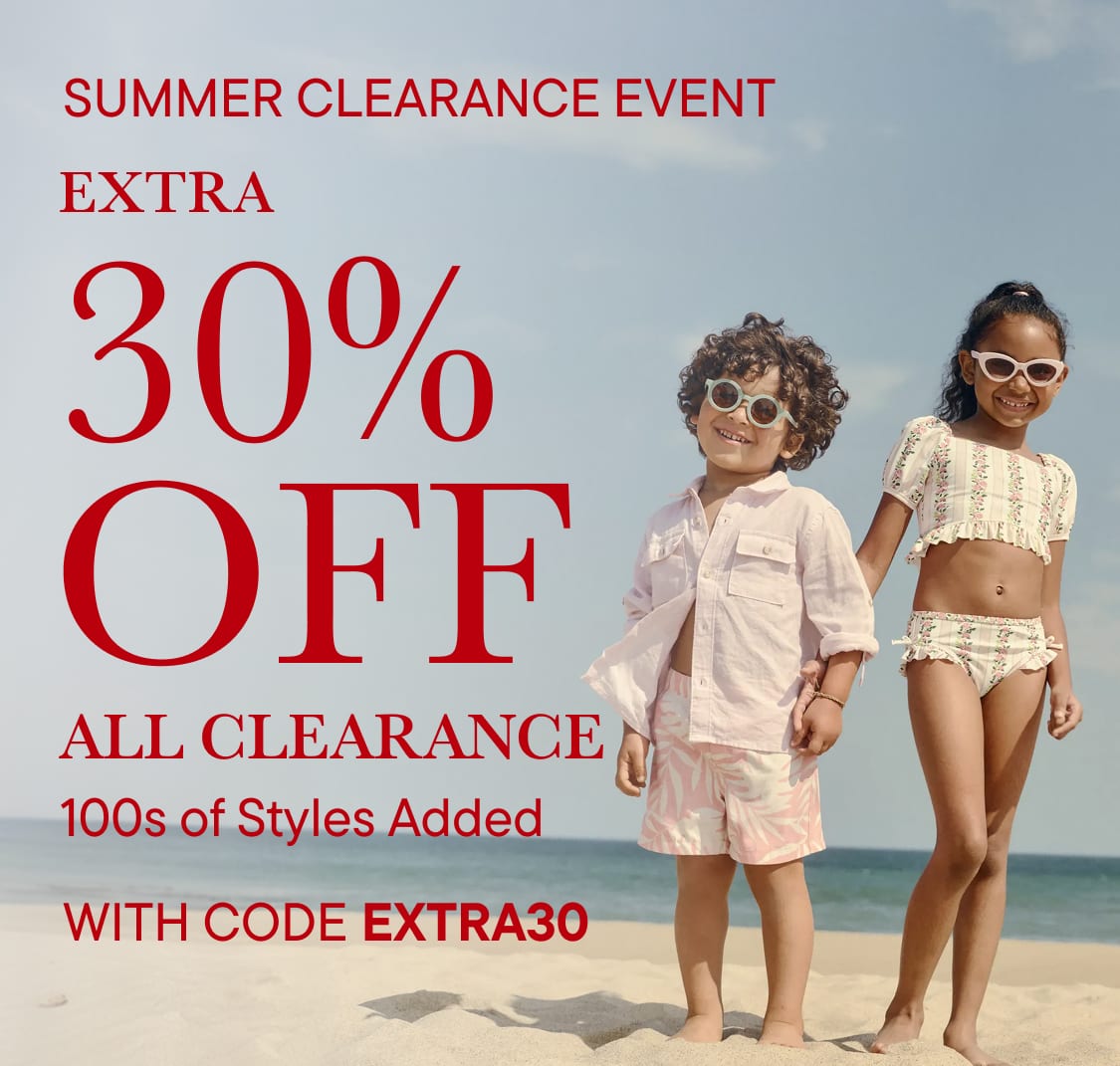 Two children in swimwear stand on a beach with a "Summer Clearance Event" advertisement in the background.